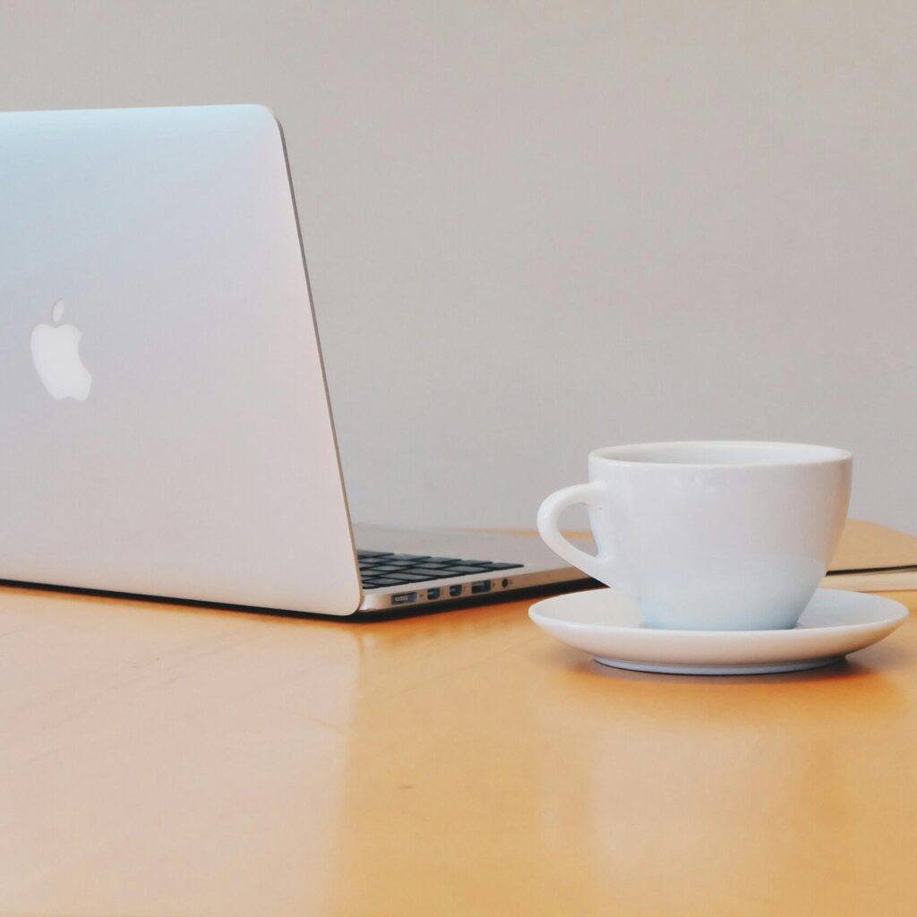 pexels-photo-257894-257894 A clean and modern workspace featuring a laptop and a white coffee cup on a wooden desk.
